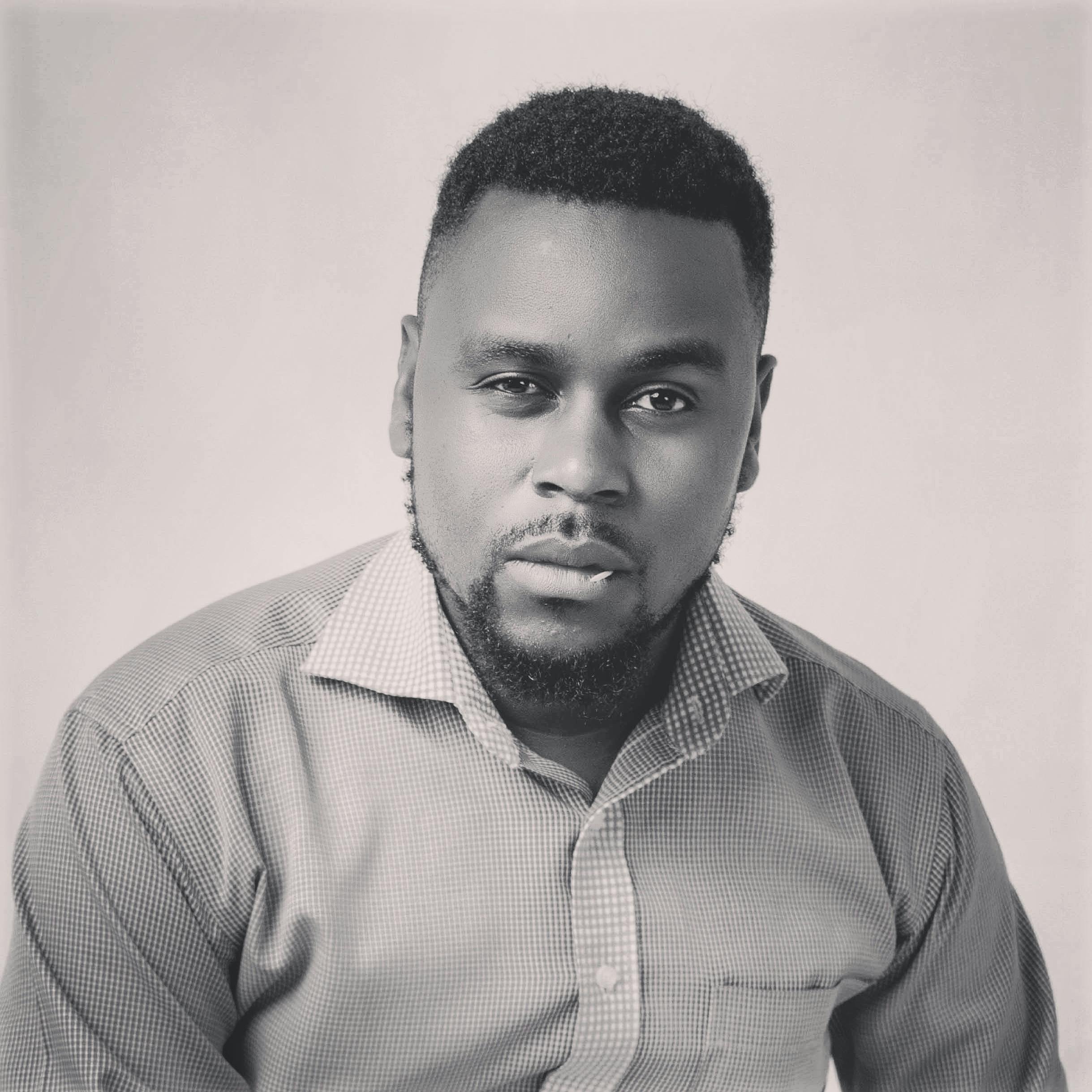 Striking monochrome portrait of a stylish man with facial hair and a confident expression.